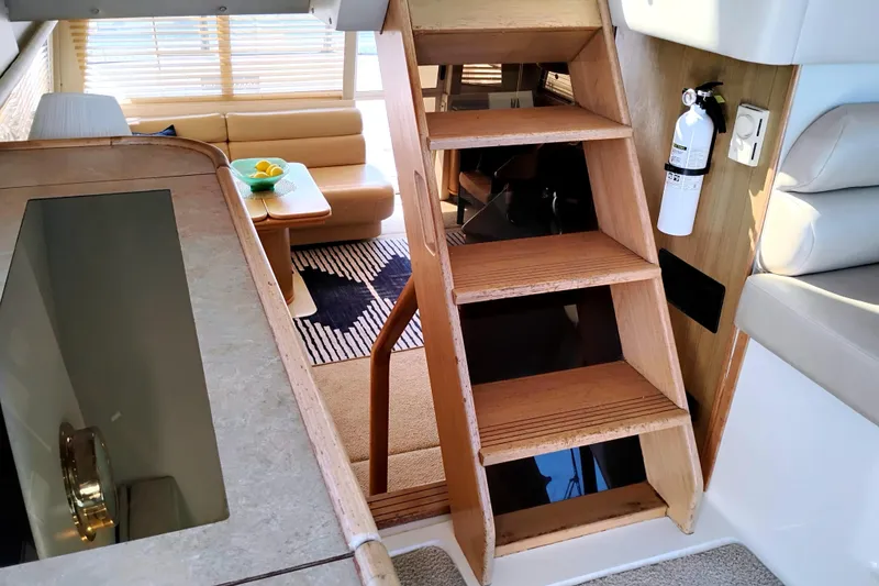 Slide: The Image of Interior of 2000 Bayliner 4788 Pilot House Motoryacht with wooden stairs and cozy seating area. - 25