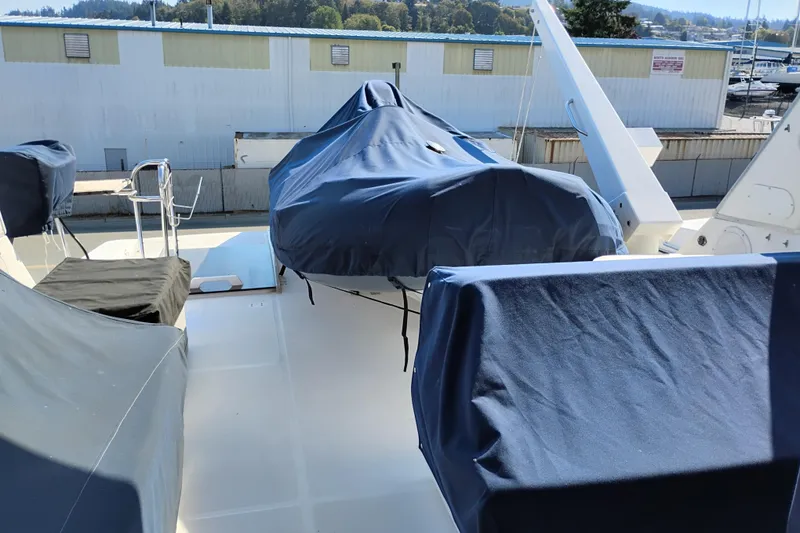 Slide: The Image of 2000 Bayliner 4788 Pilot House Motoryacht deck with covered equipment and scenic background. - 29
