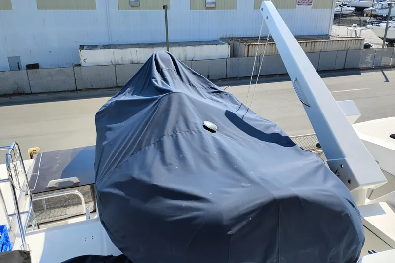 Slide: The Image of Covered Bayliner 4788 Pilot House Motoryacht, 2000 model, docked near industrial buildings. - 33