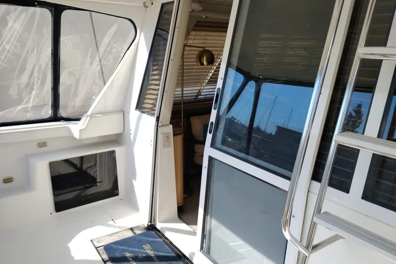 Slide: The Image of 2000 Bayliner 4788 Pilot House Motoryacht interior with sliding glass door and ladder. - 4