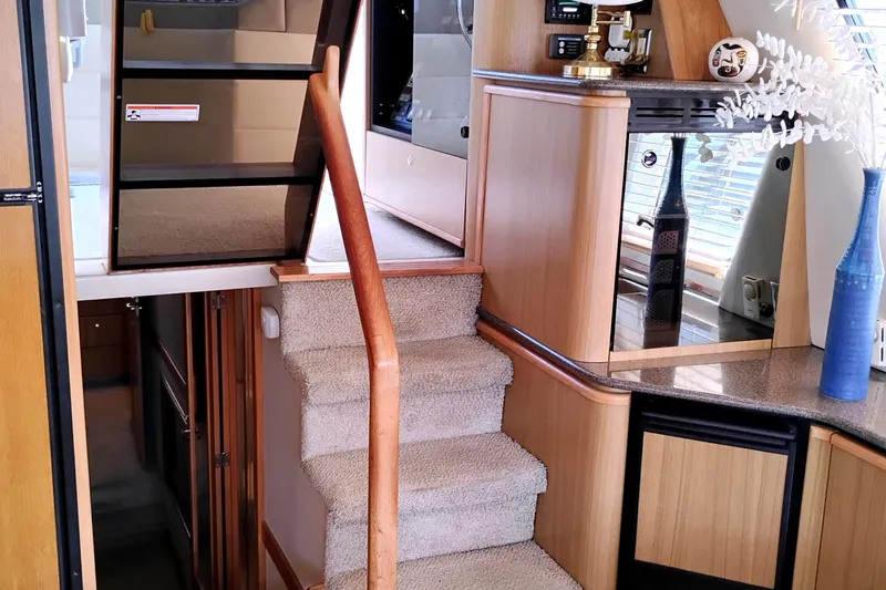 Slide: The Image of Interior of 2000 Bayliner 4788 Pilot House Motoryacht with carpeted stairs and wooden cabinetry. - 44