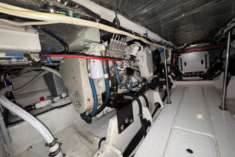 Slide: The Image of Engine room of 2000 Bayliner 4788 Pilot House Motoryacht, showcasing mechanical components and wiring. - 62