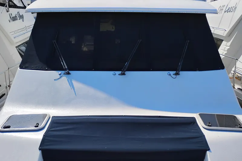 Slide: The Image of 2000 Bayliner 4788 Pilot House Motoryacht front view with covered windows and wipers. - 68