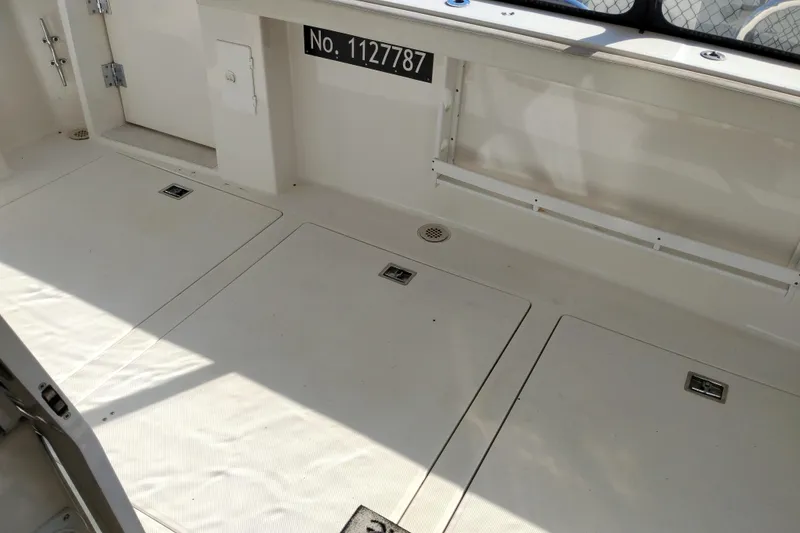 Slide: The Image of 2000 Bayliner 4788 Pilot House Motoryacht deck with storage hatches and registration number. - 7