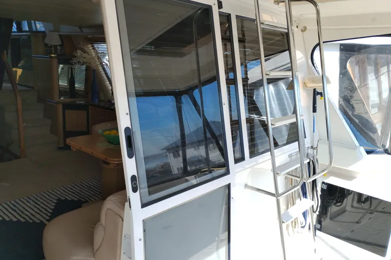 Slide: The Image of 2000 Bayliner 4788 Pilot House Motoryacht interior with sliding glass door and ladder. - 8