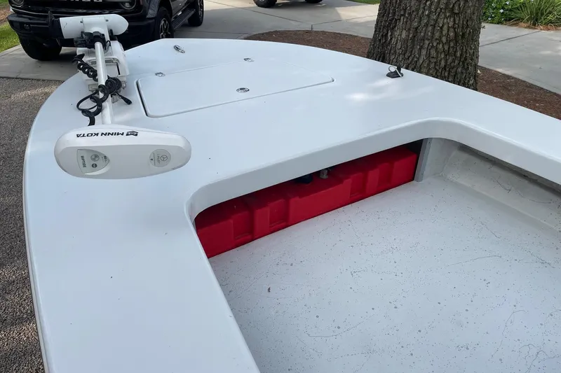 Slide: The Image of 2023 Riptide 17 Flats boat with Minn Kota trolling motor, parked near a tree. - 10