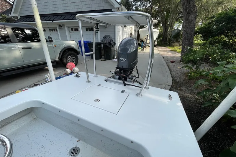 Slide: The Image of 2023 Riptide 17 Flats boat with outboard motor, parked in a driveway. - 14