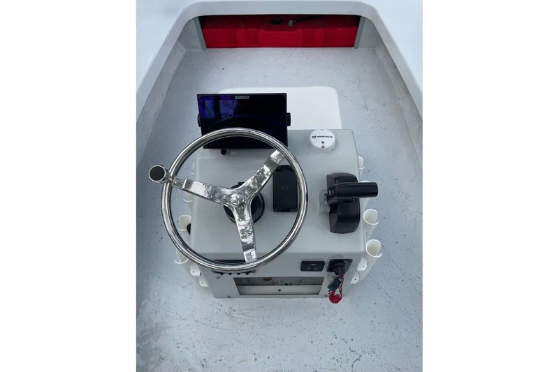 Slide: The Image of 2023 Riptide 17 Flats boat console with steering wheel and navigation equipment. - 17