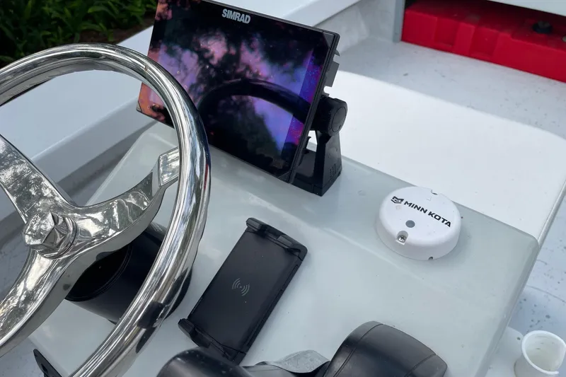 Slide: The Image of 2023 Riptide 17 Flats boat dashboard with Simrad display and Minn Kota device. - 18