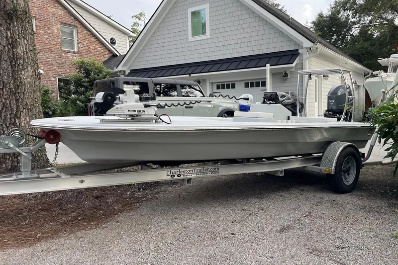 Slide: The Image of 2023 Riptide 17 Flats boat on trailer, parked in residential driveway. - 2