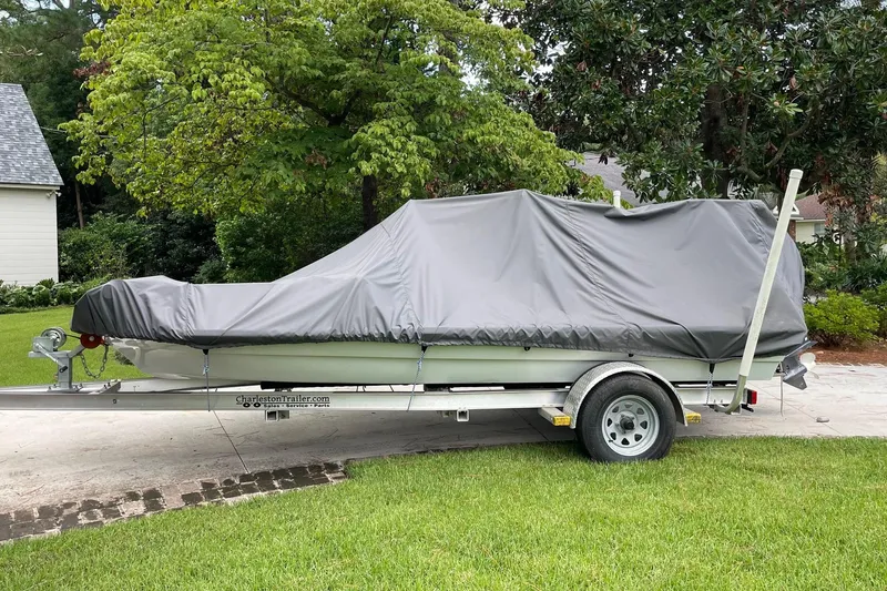 Slide: The Image of 2023 Riptide 17 Flats boat covered on trailer, parked on driveway. - 22