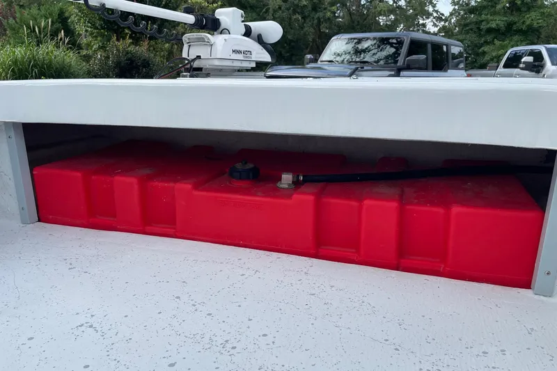 Slide: The Image of Red fuel tank in a 2023 Riptide 17 Flats boat, with Minn Kota trolling motor. - 30