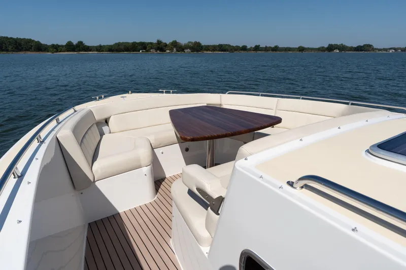 Slide: The Image of Luxurious seating area on 2023 MJM 4 boat with wooden table and cushioned seats. - 35