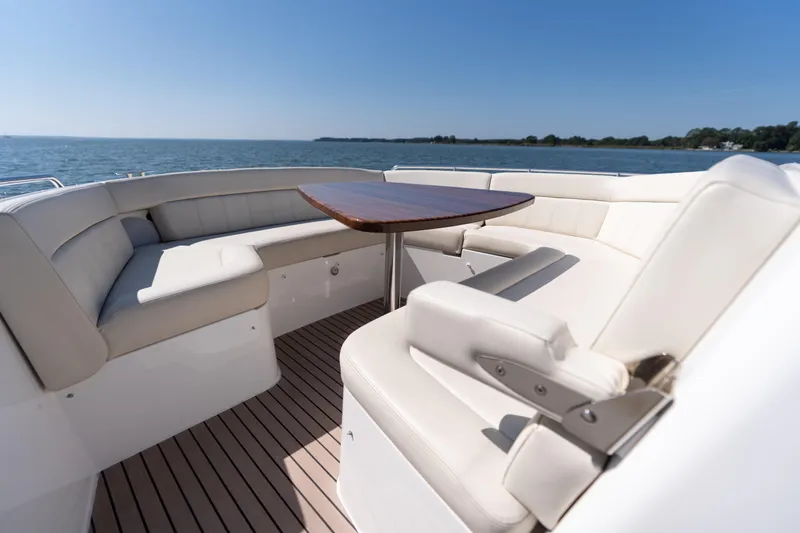 Slide: The Image of 2023 MJM Yachts 4 cruising on a serene lake under a clear blue sky. - 42