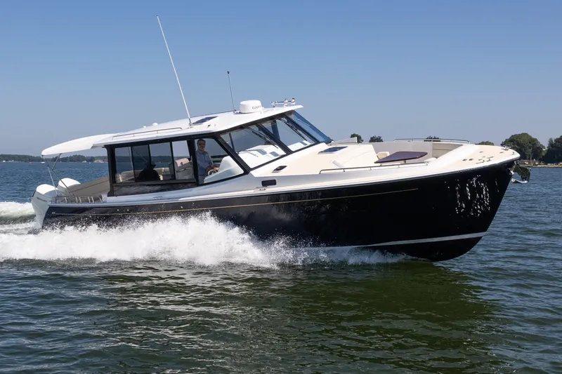 Slide: The Image of 2023 MJM Yachts 4 cruising on a serene lake under clear blue skies. - 48