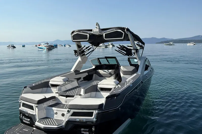 Slide: The Image of 2026 MasterCraft XStar 23 boat on calm lake with scenic mountain backdrop. - 3