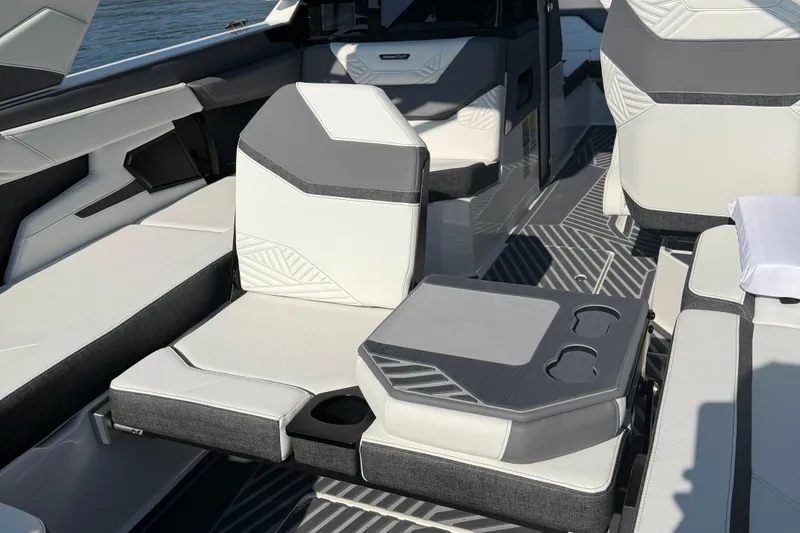 Slide: The Image of 2026 MasterCraft XStar 23 interior with modern seating and cup holders on a sunny day. - 9