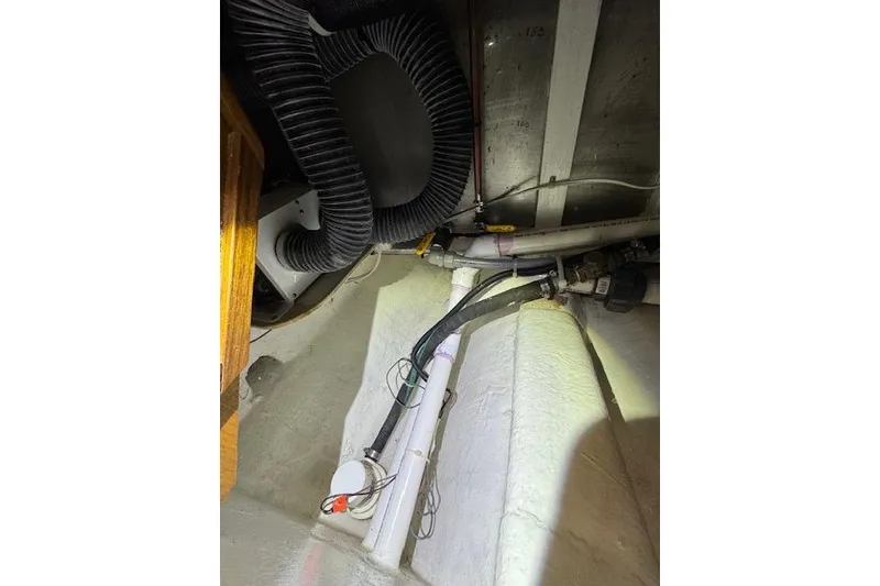 Slide: The Image of 1997 Ocean Alexander 426 Classico engine room with visible pipes and wiring. - 105