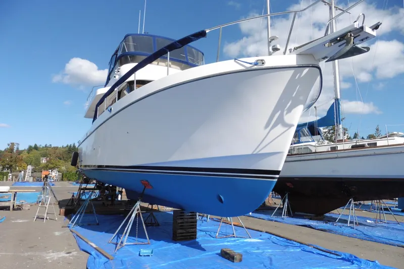 Slide: The Image of 1997 Ocean Alexander 426 Classico Sedan yacht on dry dock, blue hull, clear sky. - 106