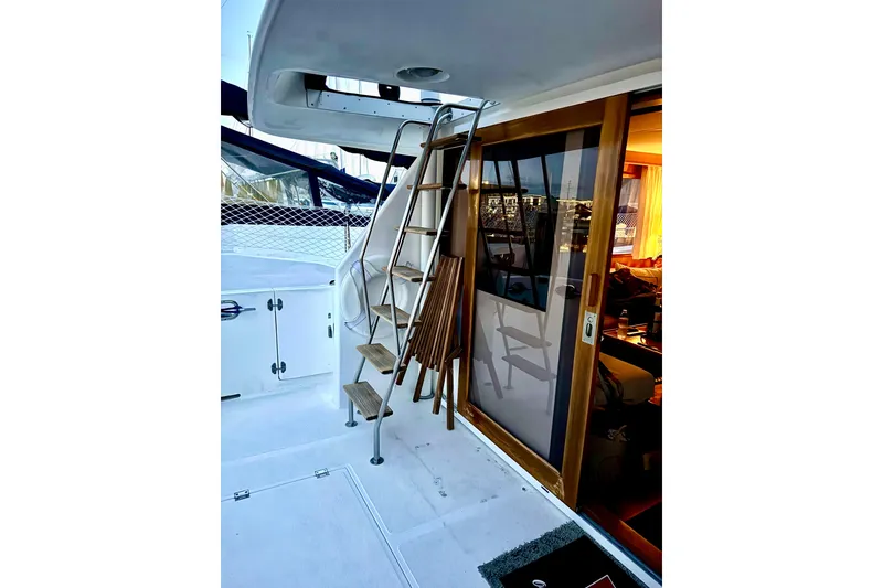 Slide: The Image of 1997 Ocean Alexander 426 Classico yacht deck with blue railing and window view. - 13