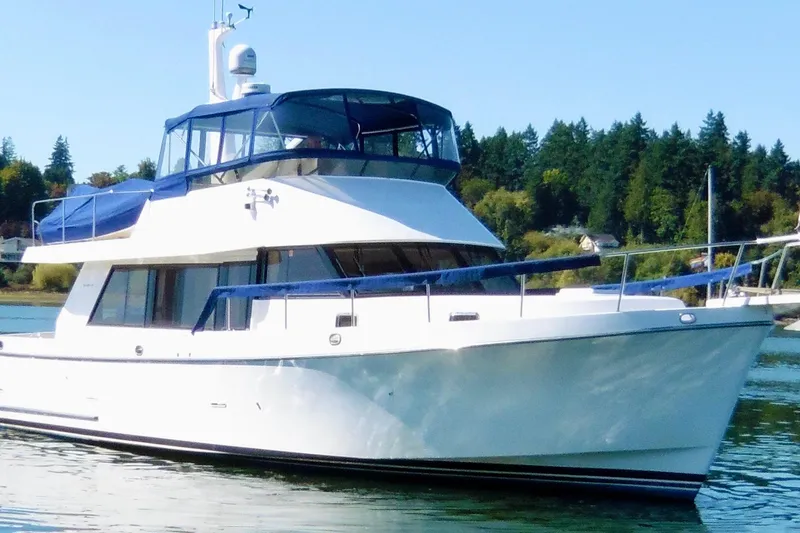 Slide: The Image of 1997 Ocean Alexander 426 Classico yacht docked on calm water, surrounded by trees. - 2