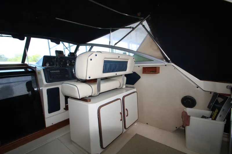 Slide: The Image of 1986 Sea Ray 340 Sundancer docked, featuring spacious cockpit and fishing gear. - 13
