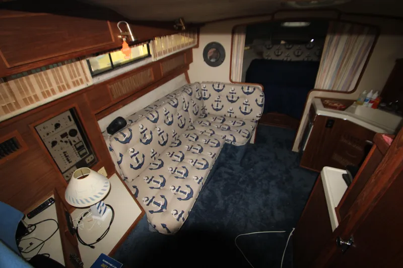 Slide: The Image of Interior of 1986 Sea Ray 340 Sundancer with nautical-themed decor and cozy seating. - 24