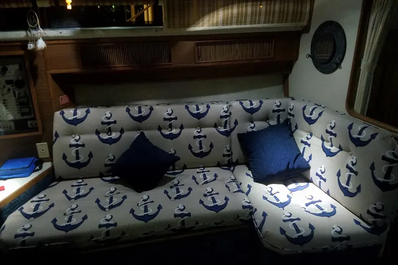 Slide: The Image of Interior of 1986 Sea Ray 340 Sundancer with anchor-patterned sofa and blue cushions. - 26