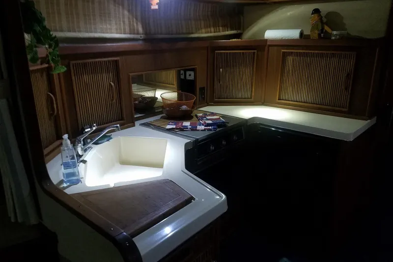 Slide: The Image of 1986 Sea Ray 340 Sundancer kitchen with wooden cabinets and modern sink. - 27