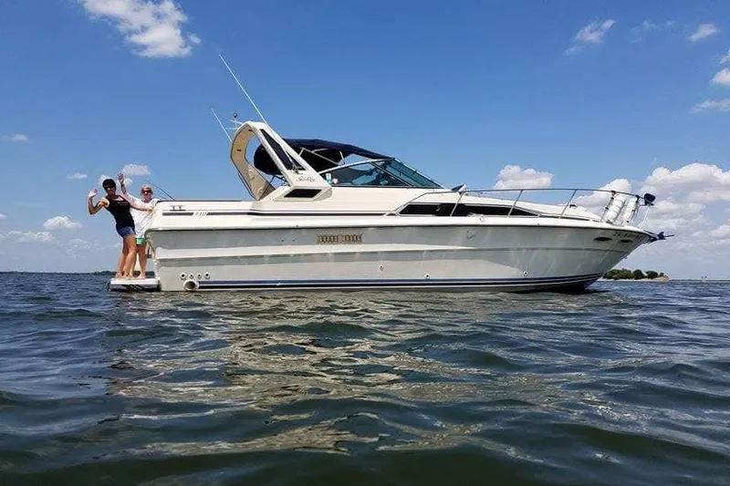 Slide: The Image of 1986 Sea Ray 340 Sundancer boat on calm water with forested background. - 3