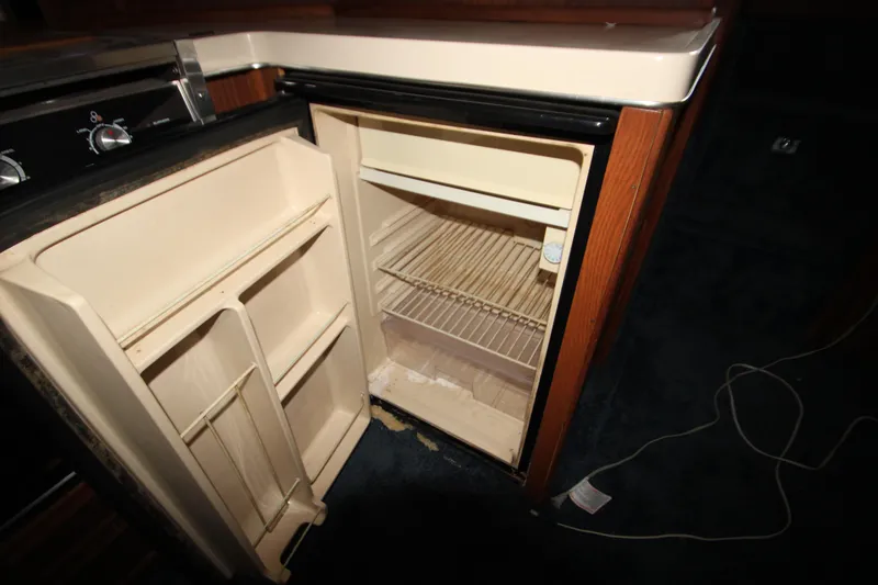 Slide: The Image of 1986 Sea Ray 340 Sundancer bathroom with toilet, sink, and wooden door. - 30