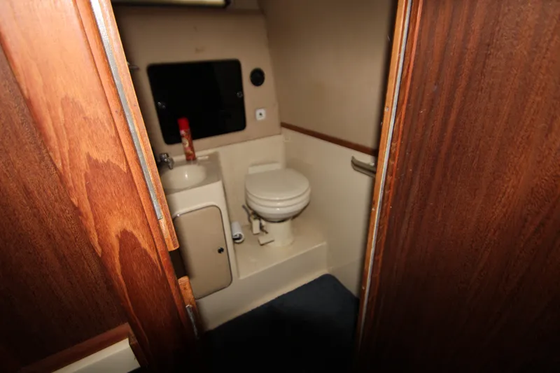 Slide: The Image of 1986 Sea Ray 340 Sundancer bathroom with sink, mirror, and toilet. - 31