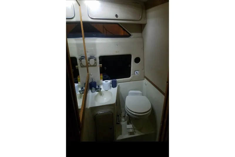 Slide: The Image of 1986 Sea Ray 340 Sundancer docked in a marina, surrounded by calm water. - 32