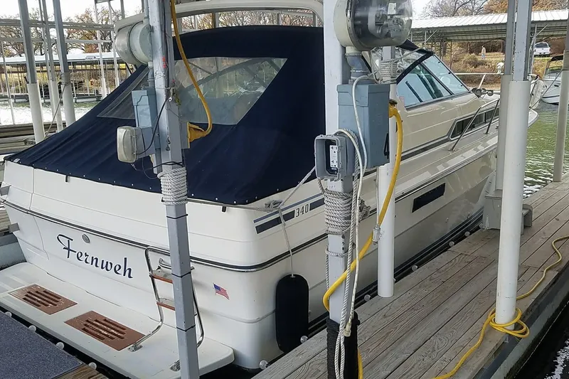 Slide: The Image of 1986 Sea Ray 340 Sundancer docked in a marina with calm waters. - 35