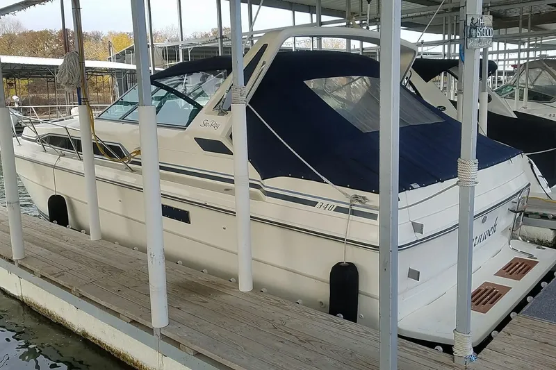 Slide: The Image of 1986 Sea Ray 340 Sundancer boat on calm water, person fishing onboard. - 4