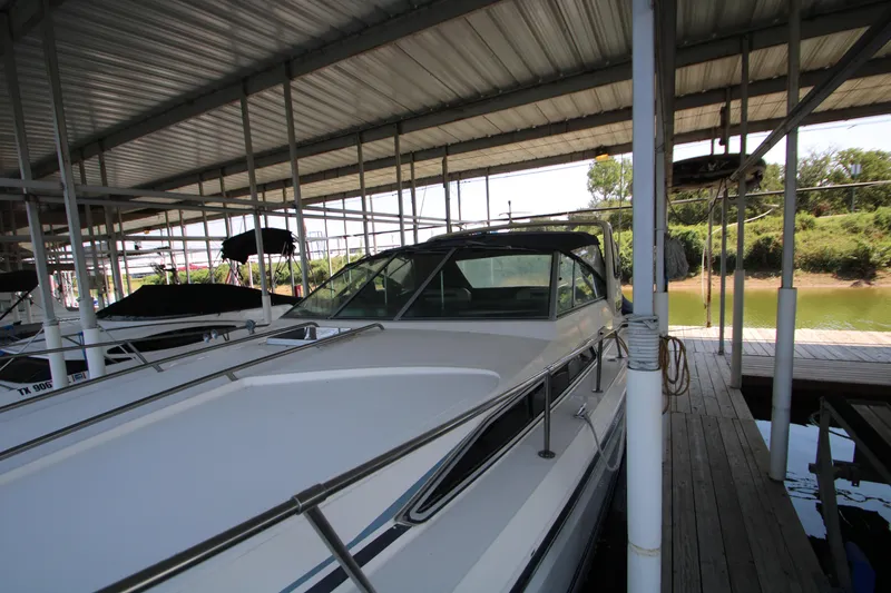 Slide: The Image of 1986 Sea Ray 340 Sundancer docked under covered marina, rear view. - 7
