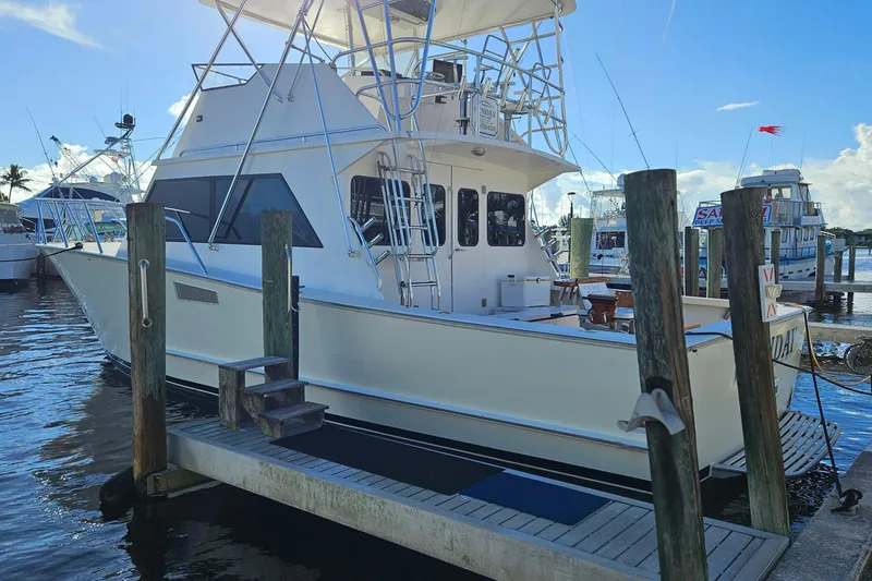 The Image of 1989 Breaux Brothers 42 Sportfisherman docked at marina under clear blue sky. - 0