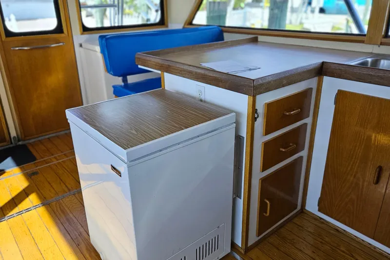 Slide: The Image of 1989 Breaux Brothers Sportfisherman interior with wooden cabinetry and blue seating. - 14