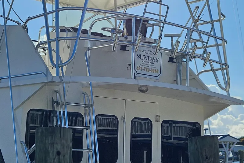 Slide: The Image of 1989 Breaux Brothers 42 Sportfisherman boat with upper deck and ladder, docked at marina. - 2