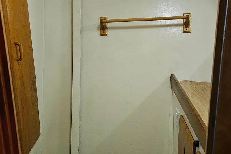 Slide: The Image of 1989 Breaux Brothers Sportfisherman interior closet with wooden rod and shelf. - 22