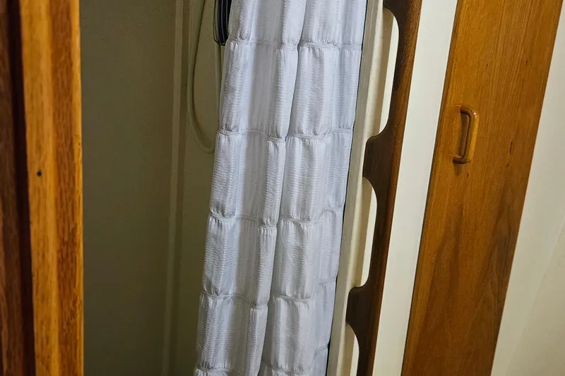 Slide: The Image of 1989 Breaux Brothers Sportfisherman interior with wooden details and white curtain. - 23