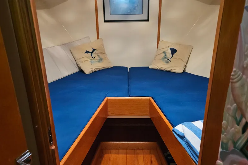 Slide: The Image of 1989 Breaux Brothers Sportfisherman cabin with blue bedding and nautical-themed pillows. - 24