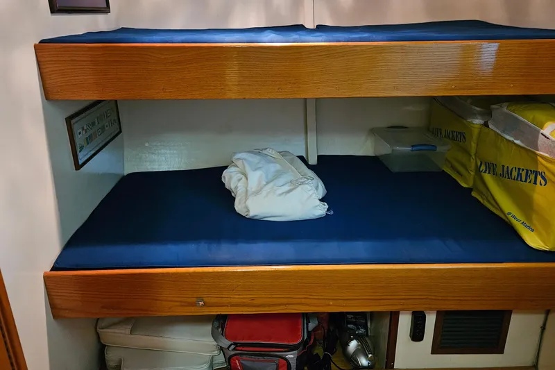 Slide: The Image of 1989 Breaux Brothers Sportfisherman cabin with bunk beds and life jackets. - 25