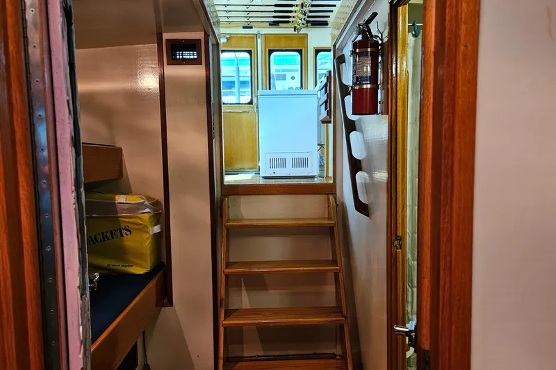 Slide: The Image of Interior of 1989 Breaux Brothers Sportfisherman boat with wooden stairs and safety equipment. - 27