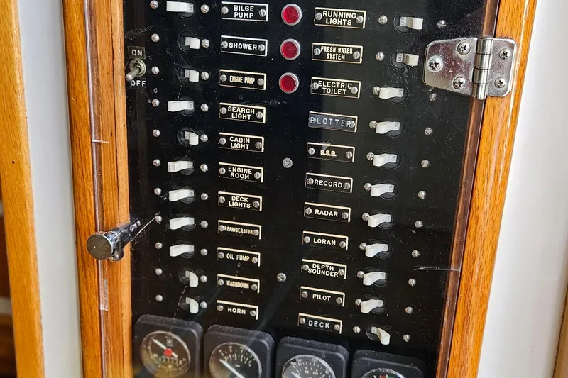 Slide: The Image of Control panel of a 1989 Breaux Brothers Sportfisherman boat with labeled switches and gauges. - 28