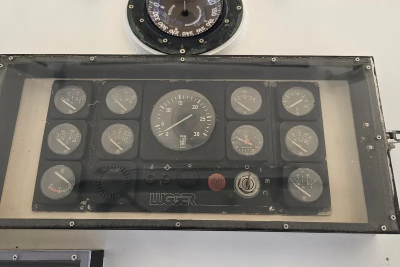 Slide: The Image of Dashboard of a 1989 Breaux Brothers Sportfisherman boat with various gauges and controls. - 36