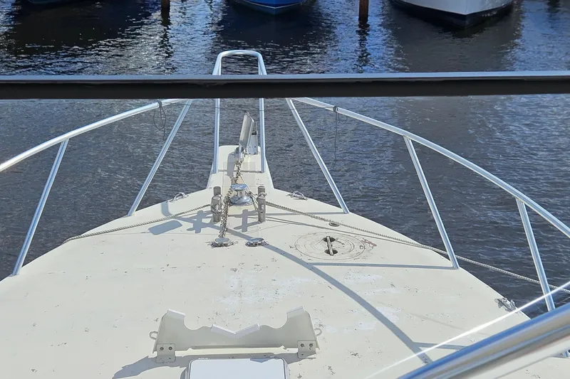 Slide: The Image of Bow view of 1989 Breaux Brothers Sportfisherman boat docked on calm water. - 39