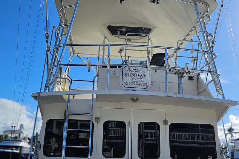 Slide: The Image of 1989 Breaux Brothers 42 Sportfisherman boat with upper deck and ladder, clear sky background. - 4