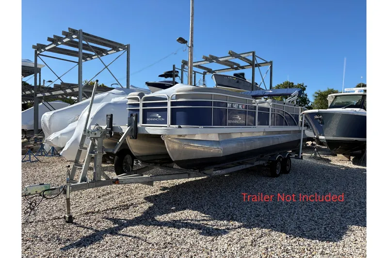 The Image of 2021 Bennington 24 SVRC pontoon boat on trailer, blue canopy, parked outside. - 0