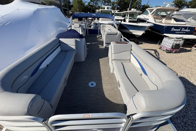 Slide: The Image of 2021 Bennington 24 SVRC pontoon boat with gray seating and blue accents. - 14